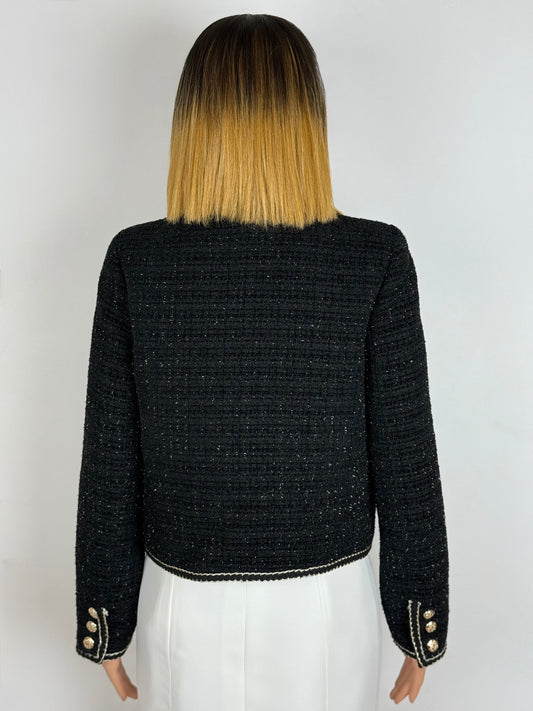 Dos de la veste en tweed noir, longues manches avec fentes, boutons et galons