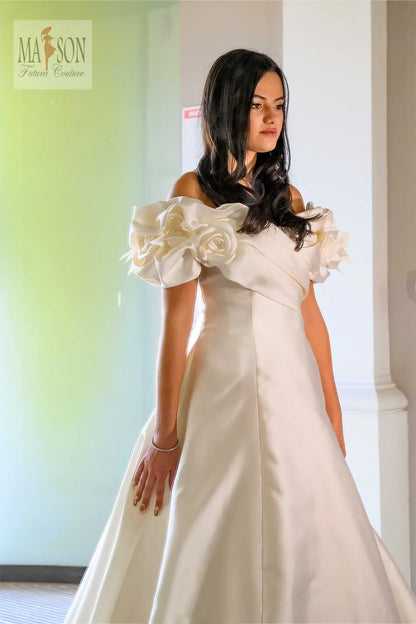 Robe de mariée longue Diva, vue de profil devant, larges bretelles ornées de fleurs, des roses, qui tombent sur les épaules, coupe structurées haute couture Futura Couture
